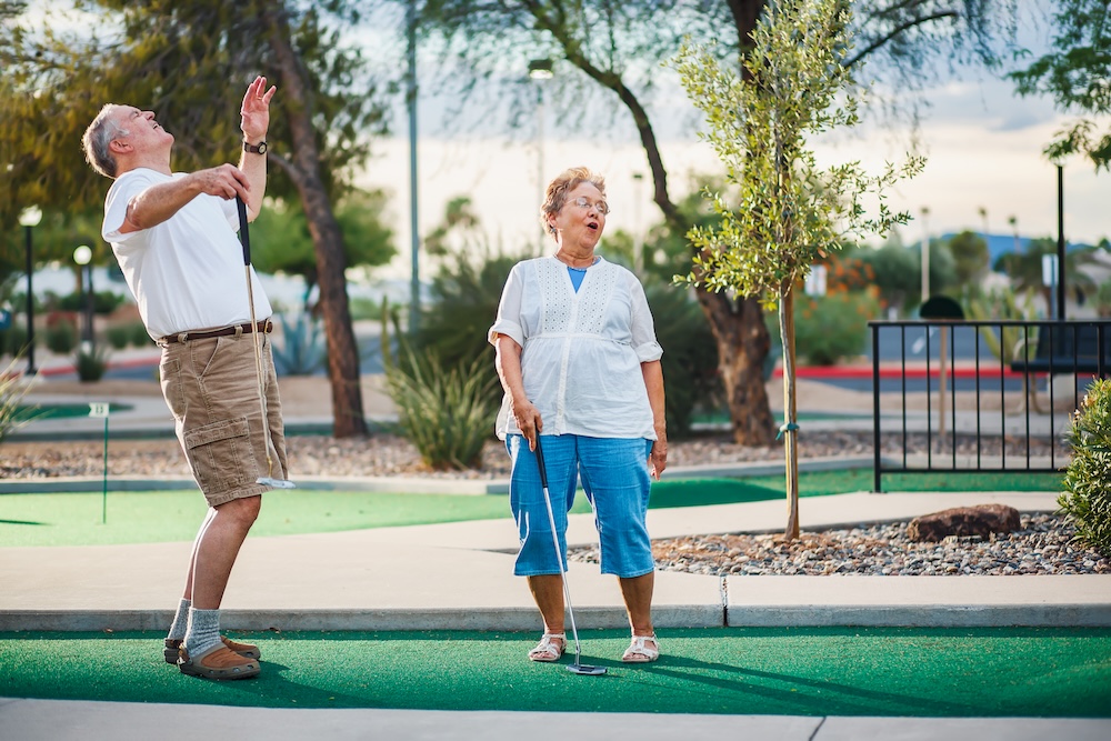 retired couple having fun playing mini golf with senior living communities Lincoln Park MI