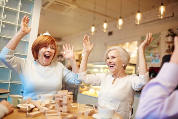 Group of senior friends playing games together and enjoying independent living Communities